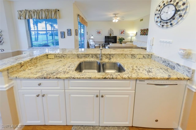 kitchen with sink, dishwasher, light stone countertops, white cabinets, and kitchen peninsula