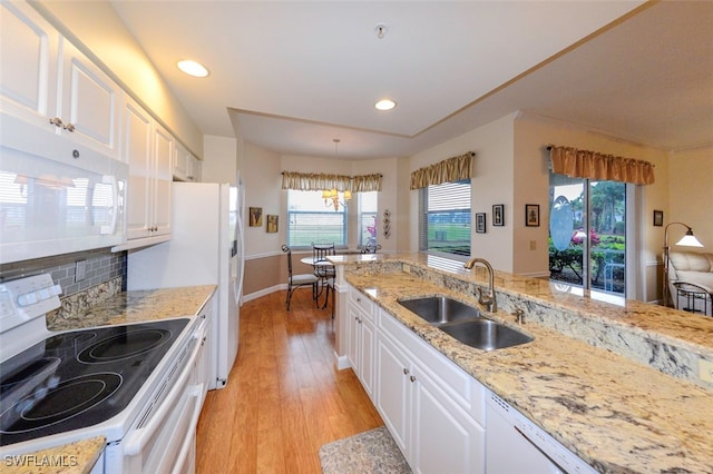 kitchen featuring sink, white appliances, white cabinetry, light hardwood / wood-style floors, and decorative light fixtures