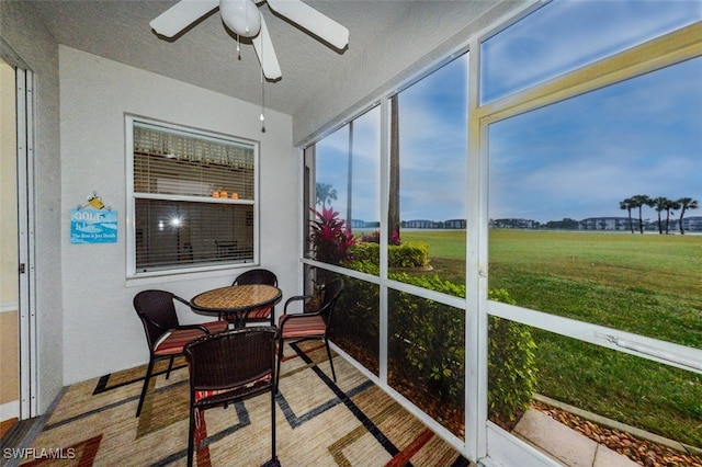 sunroom with a rural view and ceiling fan