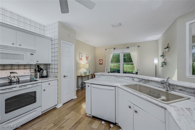 kitchen featuring sink, white appliances, white cabinetry, and light hardwood / wood-style floors