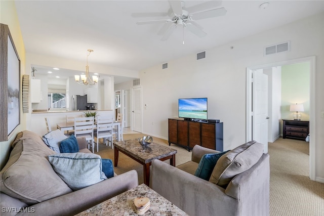 living room with light carpet and ceiling fan with notable chandelier