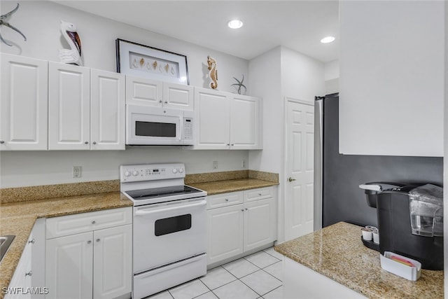 kitchen with light tile patterned flooring, white cabinetry, and white appliances