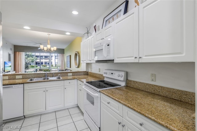 kitchen with a notable chandelier, pendant lighting, sink, white appliances, and white cabinetry