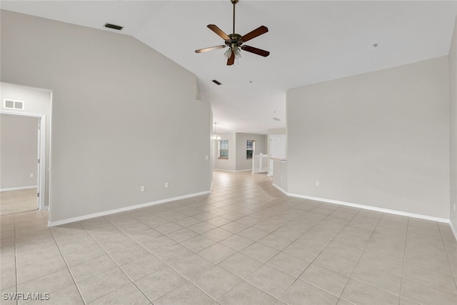 empty room with ceiling fan, vaulted ceiling, and light tile patterned floors