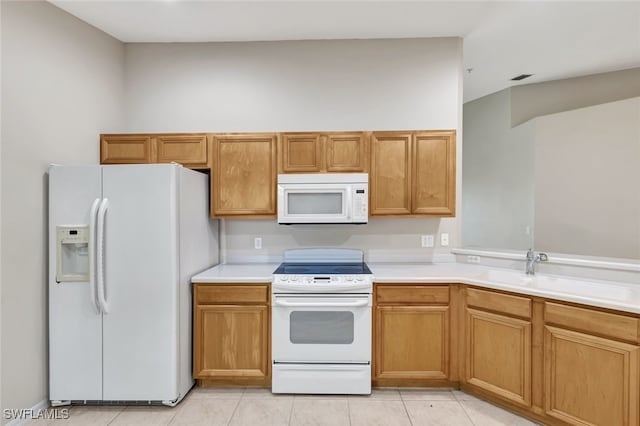 kitchen with white appliances, light tile patterned floors, and sink