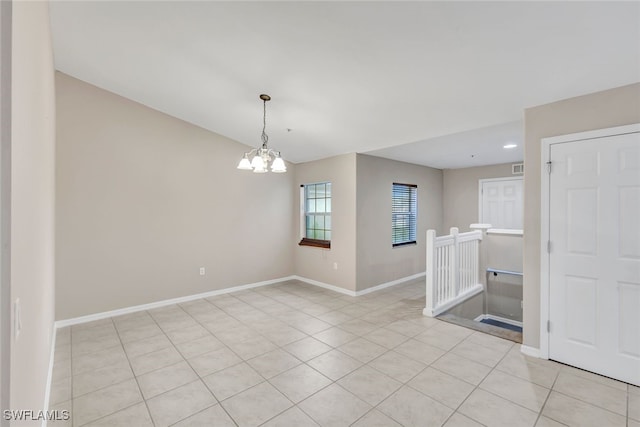 empty room featuring light tile patterned flooring and an inviting chandelier