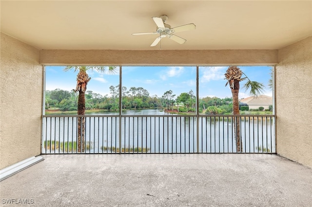 unfurnished sunroom featuring ceiling fan, a healthy amount of sunlight, and a water view