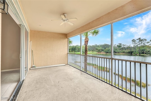 unfurnished sunroom with ceiling fan and a water view