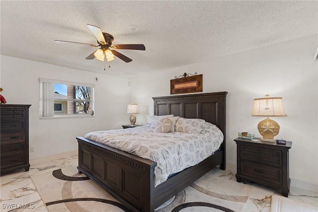 bedroom with ceiling fan and a textured ceiling