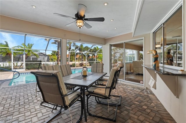 sunroom / solarium with ceiling fan and a pool