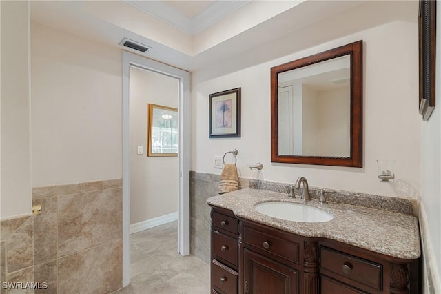 bathroom featuring vanity, tile walls, and crown molding