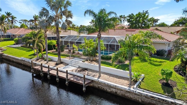 view of dock featuring glass enclosure, a lawn, and a water view