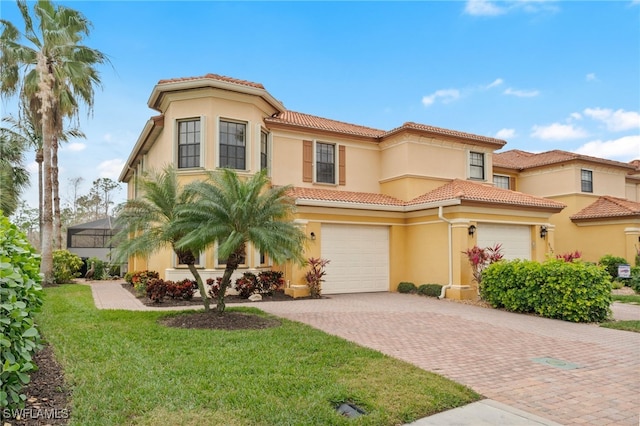 mediterranean / spanish house with a lanai, a front yard, and a garage