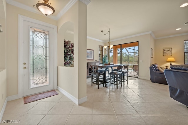 tiled entrance foyer with a notable chandelier and crown molding