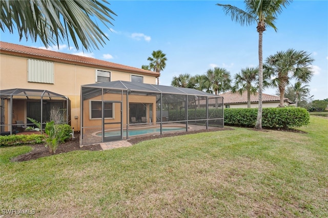 rear view of house featuring glass enclosure and a yard