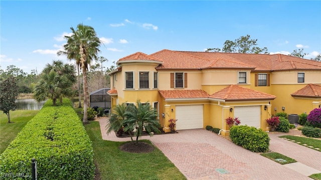 mediterranean / spanish home featuring a lanai, a garage, and cooling unit