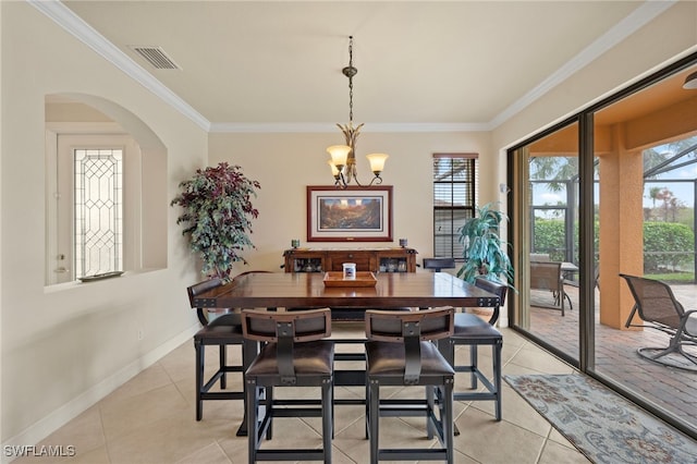 tiled dining space featuring plenty of natural light, ornamental molding, and an inviting chandelier