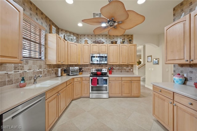 kitchen with sink, light brown cabinets, and stainless steel appliances