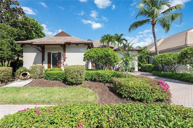 view of front of house with stucco siding, an attached garage, and driveway