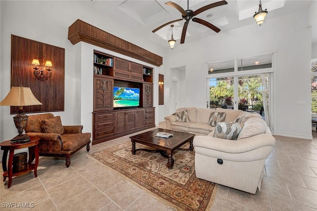 living room with beamed ceiling, coffered ceiling, a high ceiling, and ceiling fan