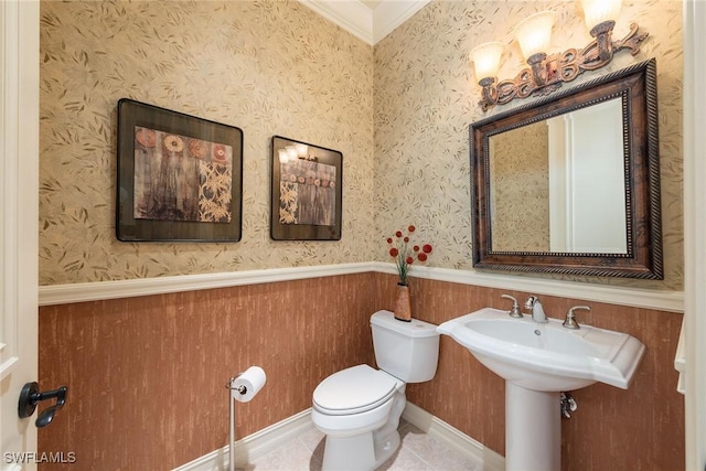 half bath with tile patterned floors, toilet, wainscoting, and wallpapered walls