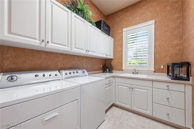 washroom featuring washing machine and clothes dryer, light tile patterned floors, cabinet space, and a sink