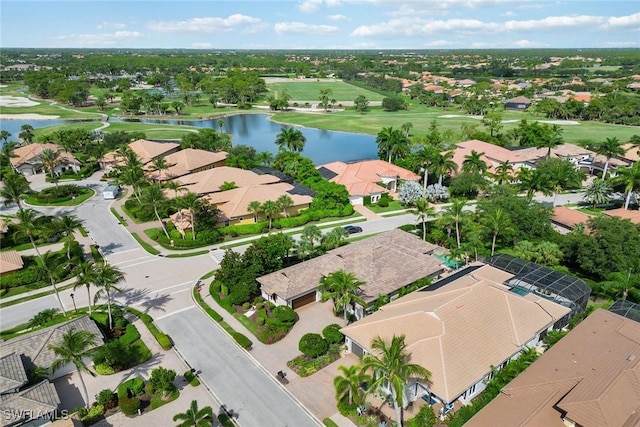 drone / aerial view with golf course view, a water view, and a residential view