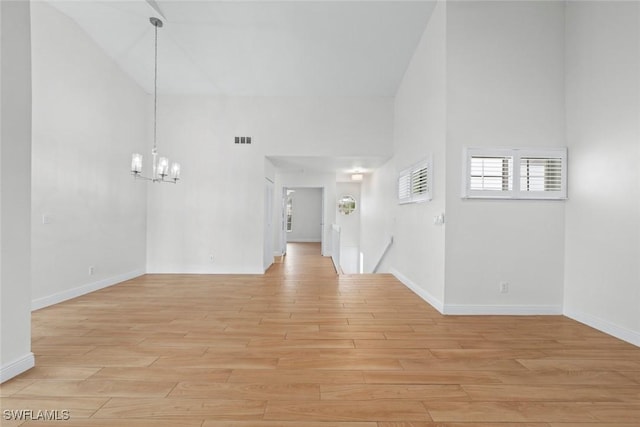 interior space featuring high vaulted ceiling, an inviting chandelier, and light hardwood / wood-style floors