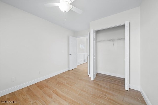 unfurnished bedroom with ceiling fan, a closet, and light wood-type flooring