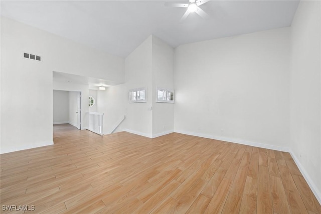 unfurnished room featuring ceiling fan, high vaulted ceiling, and light wood-type flooring