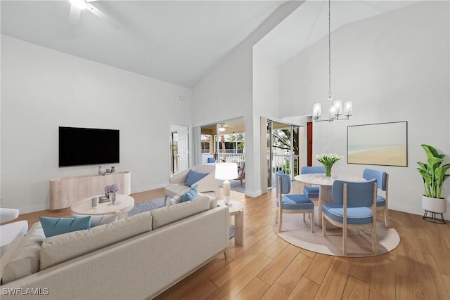 living room featuring a notable chandelier, high vaulted ceiling, and light hardwood / wood-style flooring