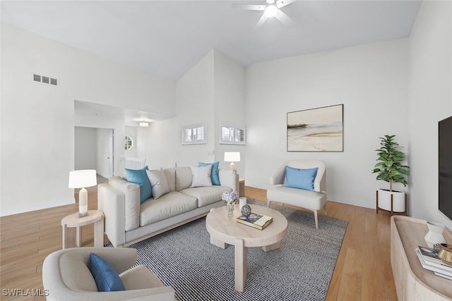 living room featuring wood-type flooring, high vaulted ceiling, and ceiling fan