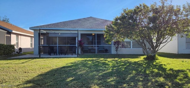 back of property featuring a sunroom and a lawn