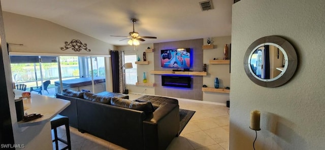 tiled living room featuring ceiling fan and vaulted ceiling