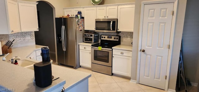 kitchen with stainless steel appliances, white cabinets, and light tile patterned flooring