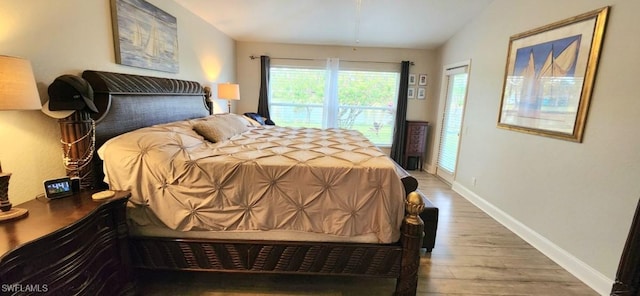 bedroom featuring vaulted ceiling and wood-type flooring