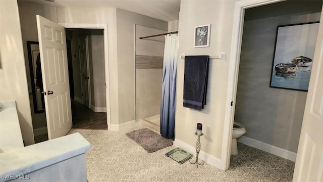 bathroom featuring toilet, tile patterned flooring, and a shower with shower curtain