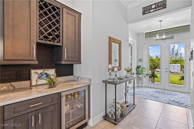 bar featuring decorative backsplash, beverage cooler, french doors, pendant lighting, and light stone counters