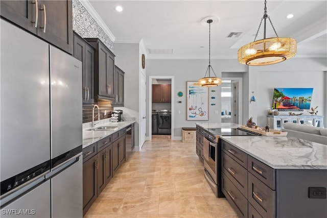 kitchen featuring pendant lighting, stainless steel appliances, sink, ornamental molding, and a center island with sink