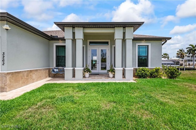 entrance to property with french doors and a yard