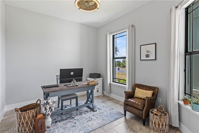 home office with light tile patterned flooring and a healthy amount of sunlight