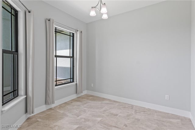 unfurnished room with a notable chandelier and a wealth of natural light
