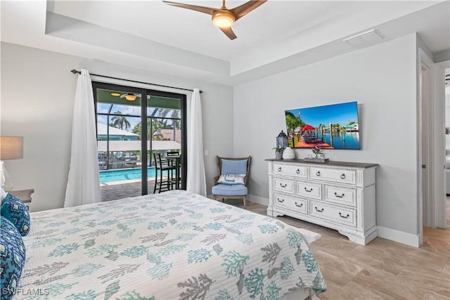 bedroom featuring ceiling fan, a tray ceiling, and access to outside