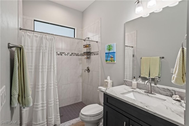 bathroom featuring toilet, vanity, and curtained shower