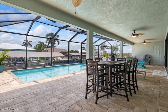 view of pool with ceiling fan, a lanai, and a patio