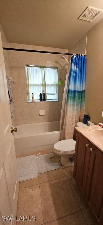 full bathroom featuring shower / bath combo with shower curtain, toilet, vanity, and tile patterned flooring