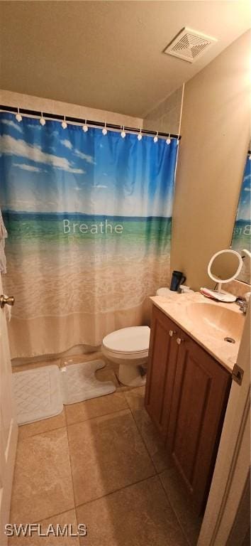 bathroom with toilet, vanity, and tile patterned floors