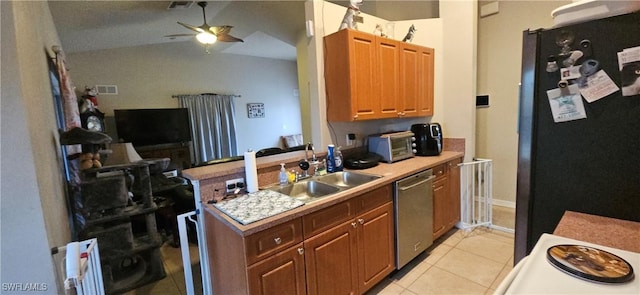 kitchen with light tile patterned floors, ceiling fan, stainless steel appliances, vaulted ceiling, and sink