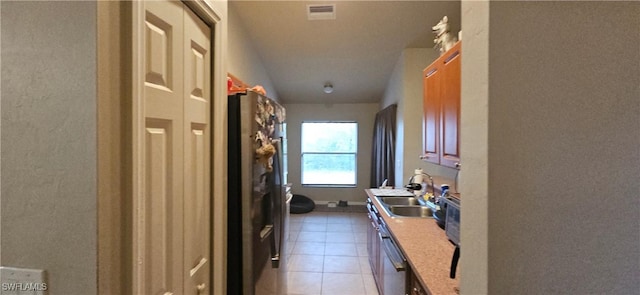 laundry area featuring sink and light tile patterned flooring