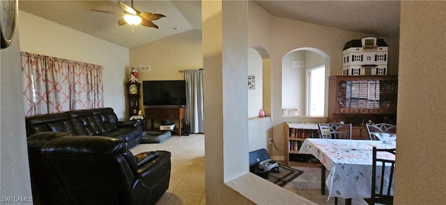 living room featuring vaulted ceiling, ceiling fan, and light tile patterned floors